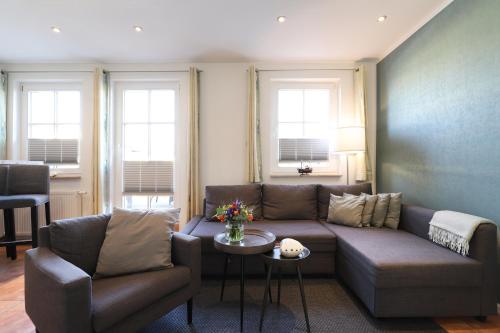 a living room with a couch and chairs and windows at Appartementhaus Strandnähe in Warnemünde