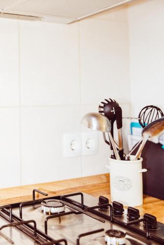 a kitchen counter with a stove top with utensils at Studio comfort in Bischenrech