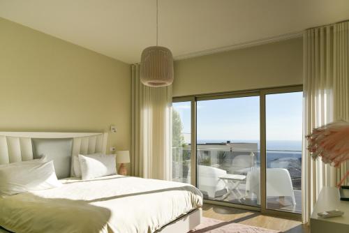 a bedroom with a bed and a view of the ocean at Villa Amazing View Funchal - Lux & Pool in Funchal