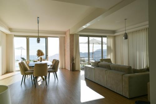 a living room with a couch and a table and chairs at Villa Amazing View Funchal - Lux & Pool in Funchal