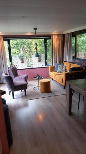 a living room with a couch and a chair at Chalets van Minicamping De Braamhof in Koudekerke