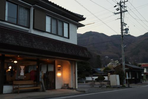 a building with a bench in front of a street at sharehouse&stay上海洋行 in Nagawa