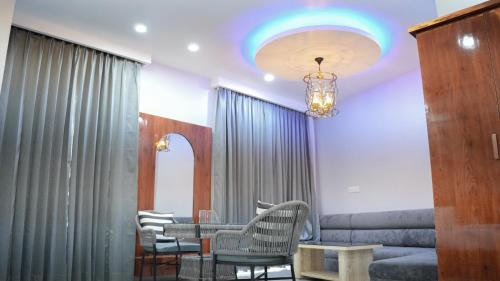 a waiting room with chairs and a table and a chandelier at Hotel Savaya Luxury Stay Near AIIMS Rishikesh in Rishīkesh