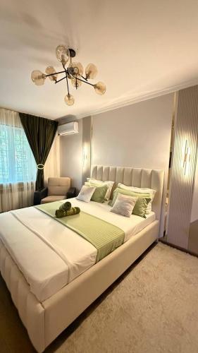 a large white bed in a bedroom with a ceiling at Family apartment comfort in Shymkent