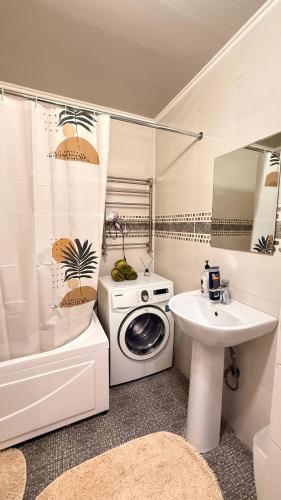 a bathroom with a washing machine and a sink at Family apartment comfort in Shymkent