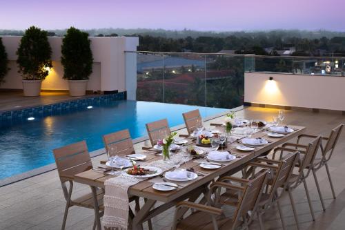 a long wooden table with chairs and food on a patio at Fortune Airport Road Kochi - Member ITC hotels' group in Cochin