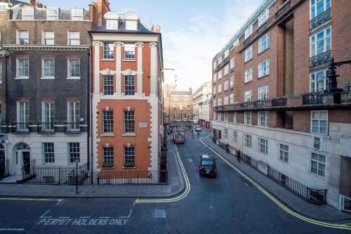 a view of a city street with buildings and cars at 9 Hertford Street - 4 Stars VisitEngland in London