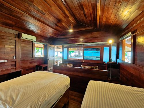 a bedroom with two beds and a wooden ceiling at Andau Dive Resort Raja Ampat in Tapokreng