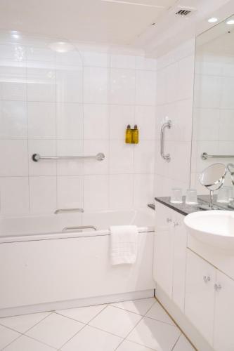 a white bathroom with a tub and a sink at 9 Hertford Street - 4 Stars VisitEngland in London