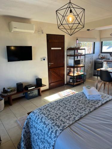 a bedroom with a bed and a tv and a table at Los Pecados de la Viuda in Punta Del Diablo