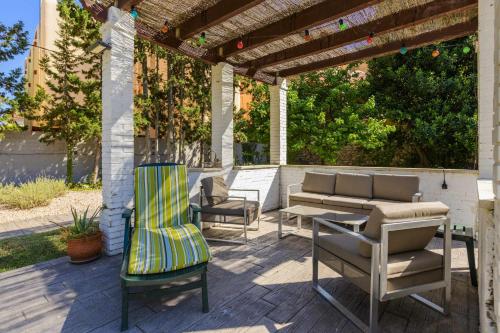 a patio with chairs and a couch and a table at Casa San Rafael, magnífico chalet con gran jardín in Navajas