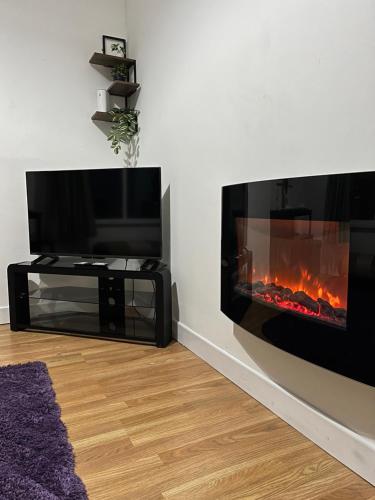a living room with a tv and a fireplace at KD Homes in Horwich