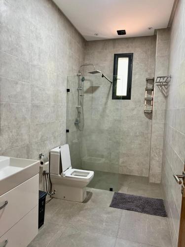 a bathroom with a shower and a toilet and a sink at Villa privée in Taazout