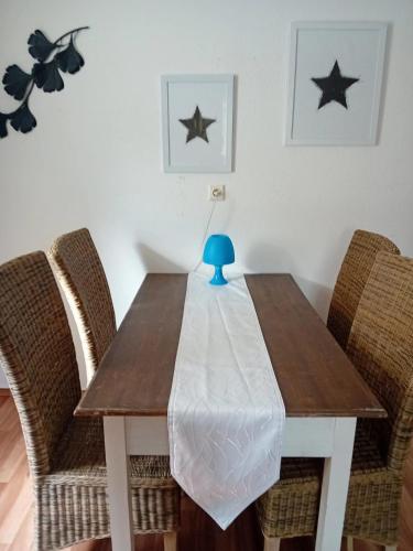 a dining room table with two chairs and a blue vase on it at Stellas Monteurwohnungen in Crimmitschau
