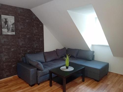 a living room with a blue couch and a table at Stellas Monteurwohnungen in Crimmitschau