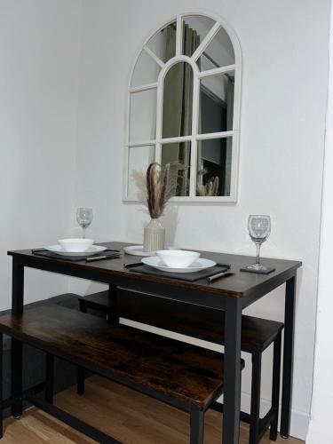 a dining room table with two glasses and a mirror at KD Homes in Horwich