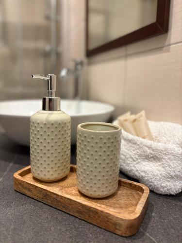 ein Badezimmer mit einer Flasche Seife und einer Tasse in der Unterkunft Rezidence U Kamenného mostu in Písek