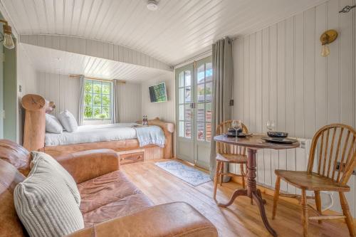 una sala de estar con una cama y una mesa en Bluebell Lodge, Lake District, en Coniston
