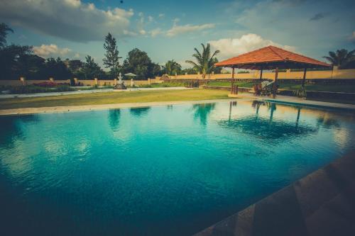 a swimming pool with a gazebo and blue water at Aeon Root Bridges by Tripture - Villa at Nandi Hills in Nandi