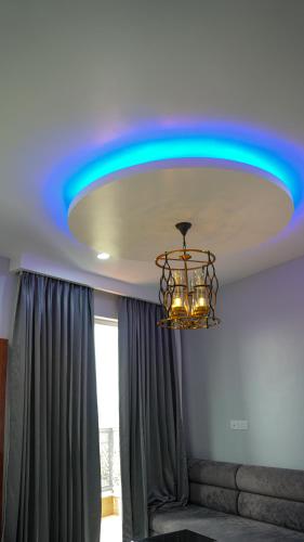 a blue light on a ceiling with a chandelier at Hotel Savaya Luxury Stay Near AIIMS Rishikesh in Rishīkesh