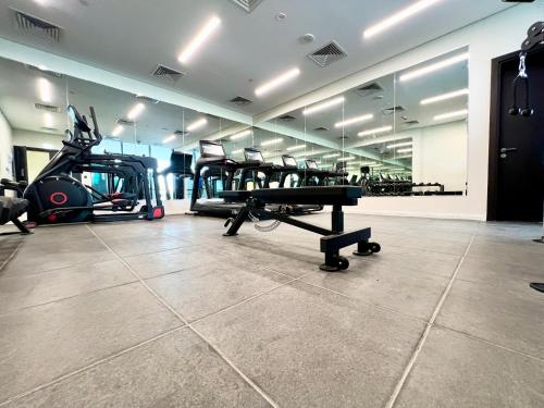 a gym with treadmills and machines in a room at Modern 2BR Retreat at The Gate in Masdar City in Abu Dhabi