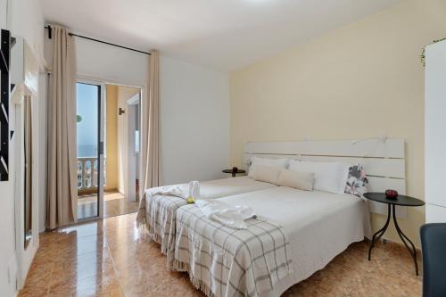 a white bedroom with a bed and a balcony at Loft Pension Candelaria in Valle Gran Rey