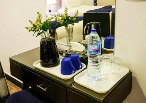 a desk with a bottle of water and a mirror at Hotel Oban in Lahore