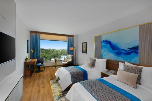 a hotel room with two beds and a flat screen tv at Fortune Airport Road Kochi - Member ITC hotels' group in Cochin