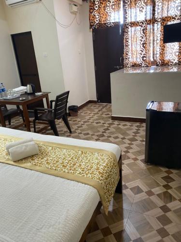 a room with two beds and a table and a window at Hotel The Calangute Central in Baga
