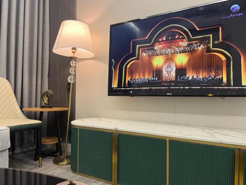 un soggiorno con una TV a schermo piatto su una parete di شقــة فخمـــة a Shaqra