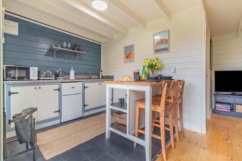 a kitchen with blue walls and a table and chairs at The Bollard at the Anchorage in Sculthorpe