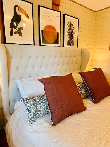 a bedroom with a white bed with pictures on the wall at The annex on our farm in Colwyn Bay