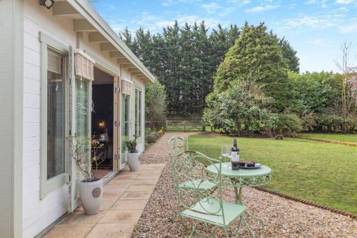 a patio with a table with a bottle of wine at The Bollard at the Anchorage in Sculthorpe