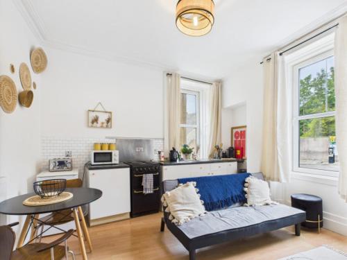 a living room with a couch and a kitchen at Allars Bank Apartment in Hawick