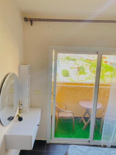 a room with a sliding glass door with a table at Porto Sharm Family Chalet with Pool View in Sharm El Sheikh