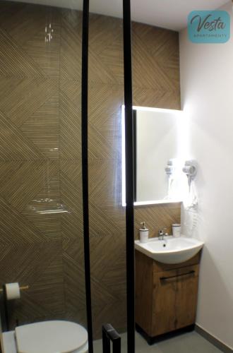 a bathroom with a toilet and a sink at VESTA Apartamenty M52 Free parking in Szczecin