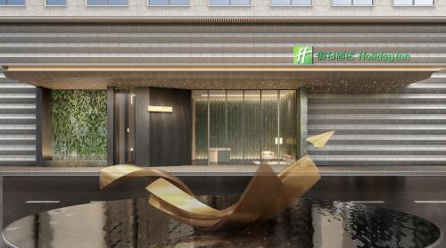 a building with a reflection of a chair in a pond at Holiday Inn Wenzhou Airport by IHG in Wenzhou