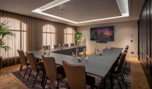 a large conference room with a long table and chairs at Clayton Hotel Amsterdam American in Amsterdam