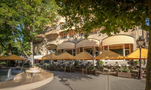 a restaurant with tables and umbrellas in front of a building at Clayton Hotel Amsterdam American in Amsterdam