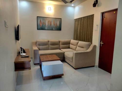 a living room with a couch and a coffee table at Dalal Residency in Kottakkal
