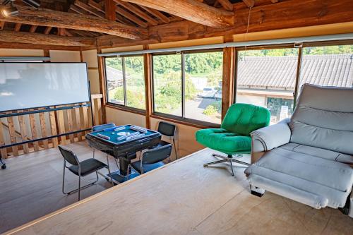 a room with a table and chairs and a screen at HANABI棟-BASE棟 サウナ BBQ 農業体験 花火 が楽しめる ペット可 貸し切りで最大12名宿泊可能 Wi-Fi完備 in Katori