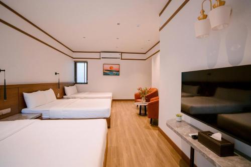 a hotel room with two beds and a flat screen tv at Toàn Cầu Hotel Quảng Bình in Dong Hoi