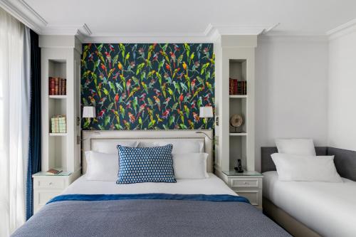 a bedroom with a bed with a painting on the wall at Hotel Monge in Paris