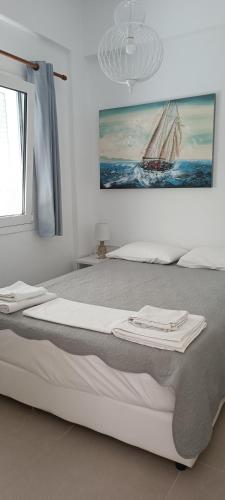 a bedroom with a bed with two towels on it at Carolina Apartments Crete in Agia Pelagia