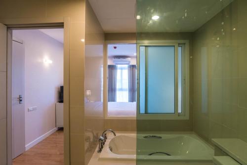 bagno con vasca e specchio di Harmony Resort Hotel a Chiang Mai