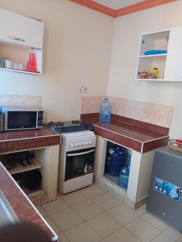 een keuken met een fornuis en een aanrechtblad bij Mtwapa Luxurious Residence with Pool B1M in Mombasa