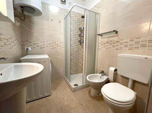 a bathroom with a toilet and a sink and a shower at Comfy flat with terrace 250mt from the sea in Porto Santa Margherita di Caorle