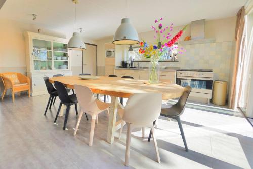 a dining room table with chairs and a vase of flowers at Sandy 25 in Callantsoog