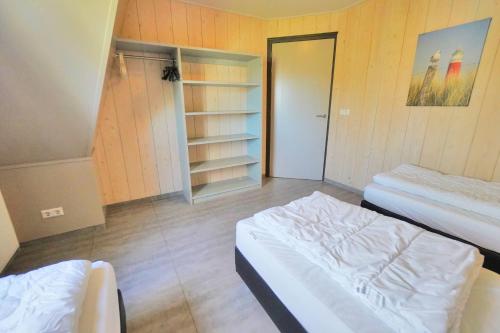 a small room with two beds and a closet at Sandy 25 in Callantsoog