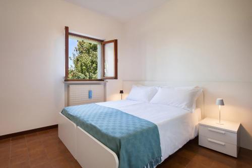 a bedroom with a white bed and a window at Apartment Noal in Calmasino